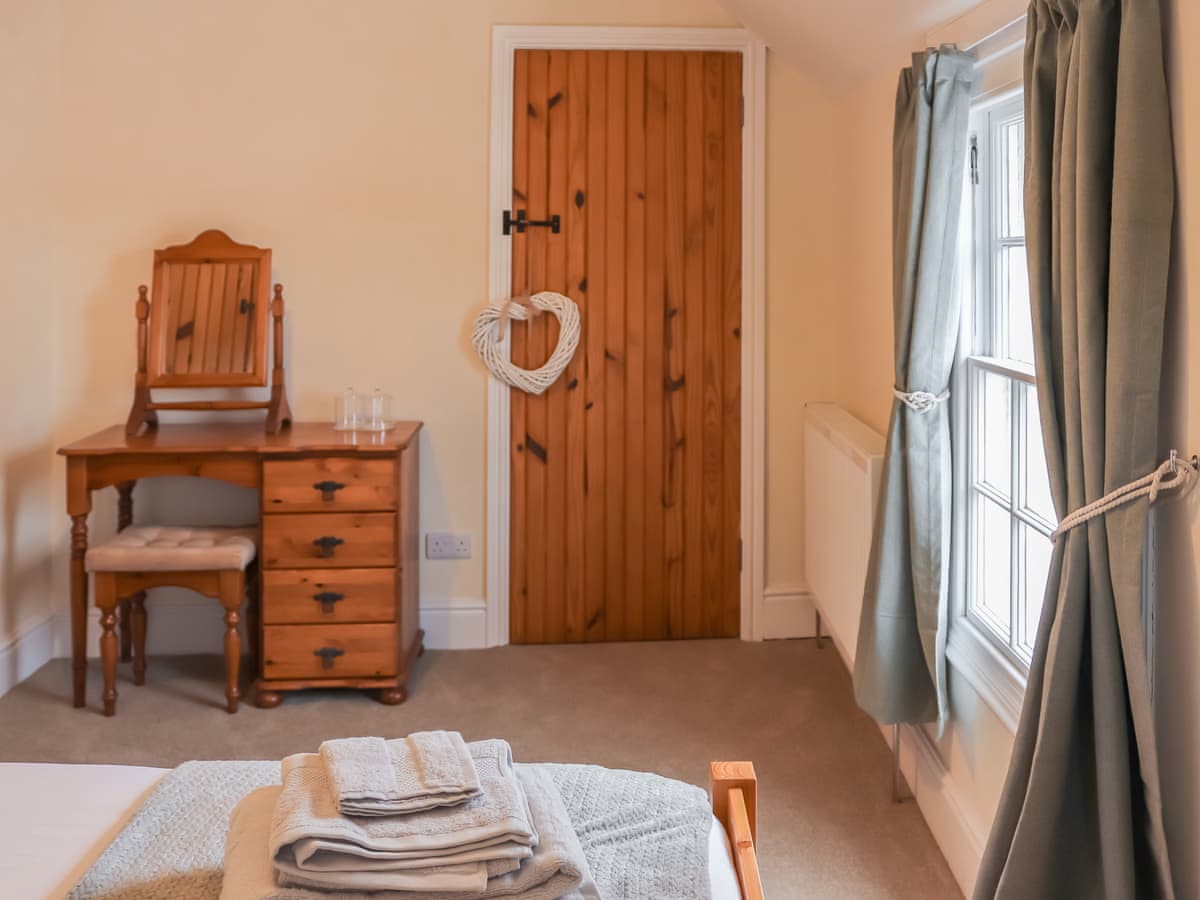 Wooden cottage door and dressing table in double bedroom
